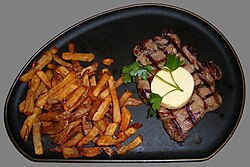 Un plato clásico de steak frites con filete y patatas fritas.
