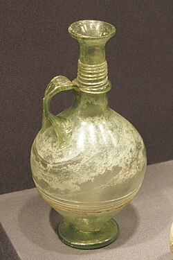 Jarra de vidrio hallada en el museo de Valladolid, reflejando el impulso romano en las técnicas de soplado.
