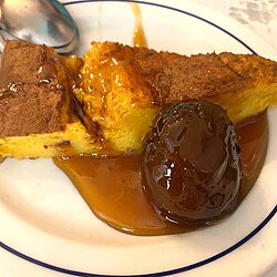 Sericaia tradicional servida en un plato con ciruelas guisadas y almíbar