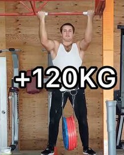 Atleta realizando una dominada con peso añadido