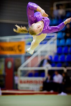 Una gimnasta realizando un giro técnico en el suelo.