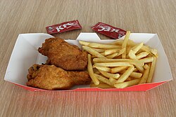 Porción de pollo frito con patatas fritas