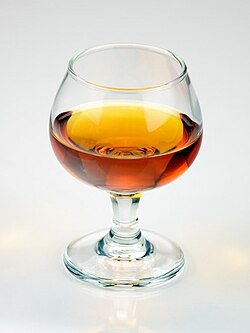 Botella y copa de coñac con información general de origen y graduación alcohólica.