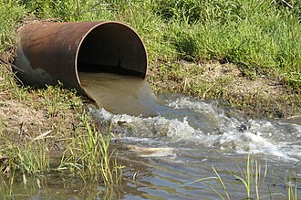 Vertido de aguas contaminadas en un cuerpo de agua.