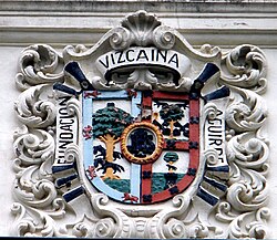 Escudo en el frontispicio de La Comercial