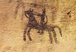 Pintura rupestre prehistórica de un caballo y jinete