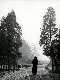 Monja visitando un cementerio en el Día de los Difuntos
