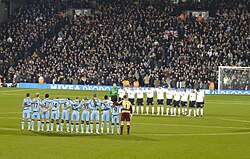Jugadores de fútbol guardan un minuto de silencio antes de un partido.