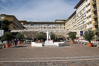 Entrada principal del hospital con la estatua de San Juan Pablo II