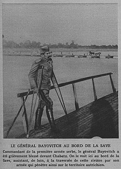 Petar Bojović apoyado en muletas junto a la orilla del río Sava observando el avance de sus tropas.