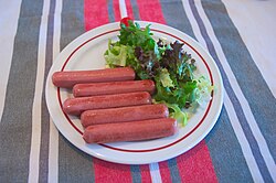 Salchichas servidas con ensalada