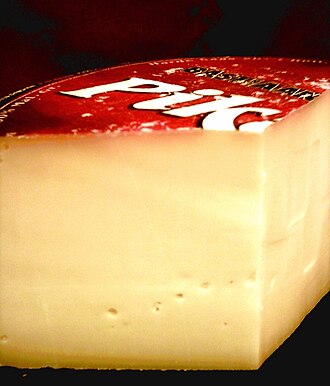 Pieza cilíndrica de queso gouda con su característica forma y textura