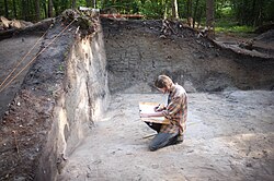 Arqueólogo examina entierros de cremación de la Edad Media en Chodlik, Polonia.