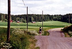 Mujer caminando en un camino rural en Finlandia