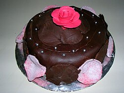 Tarta decorada con crema de chocolate y pétalos comestibles.