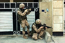 Soldados utilizando rodilleras en un contexto militar.