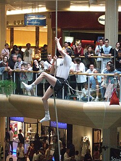 Un competidor asciende la cuerda en un centro comercial