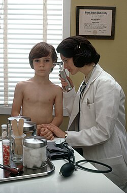 Pediatra examinando a una niña con un otoscopio